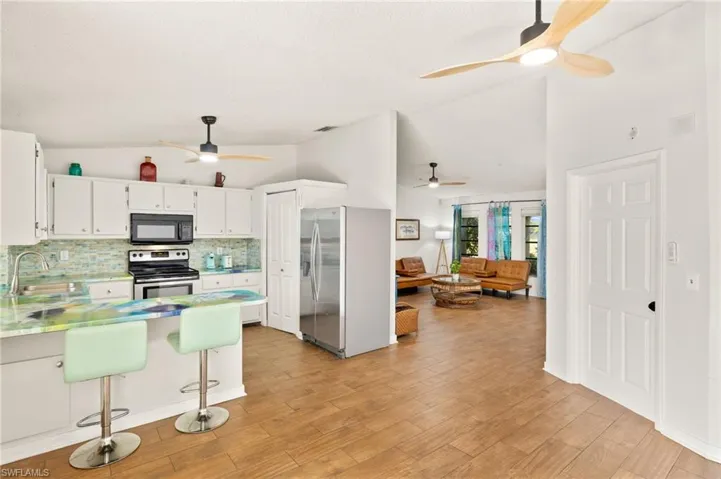 Kitchen featuring stainless steel appliances, backsplash, a sink, a peninsula, and ceiling fan