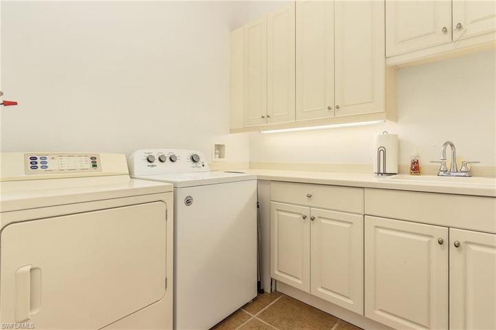 Laundry has washer and dryer, full size sink, and ample counter and cabinet space.