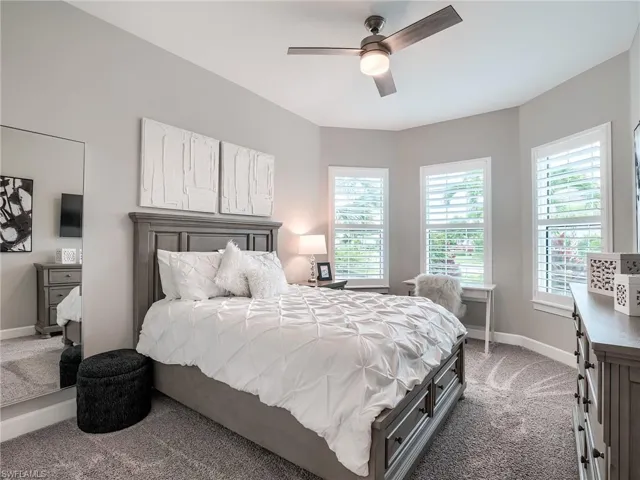 Carpeted bedroom featuring ceiling fan