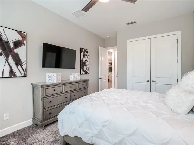 Carpeted bedroom featuring a closet and ceiling fan