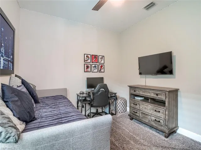 Carpeted bedroom featuring ceiling fan