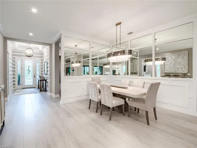 Dining area with crown molding, light hardwood / wood-style flooring, and a chandelier
