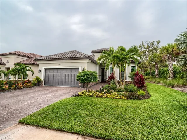 Mediterranean / spanish house featuring a garage and a front yard