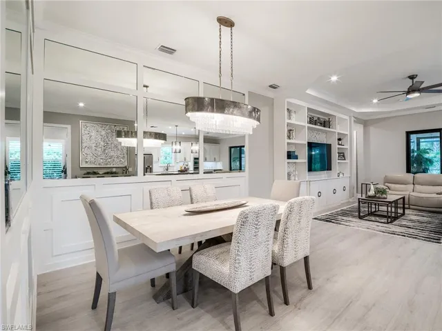 Dining space with light wood-type flooring, ceiling fan, ornamental molding, and built in shelves