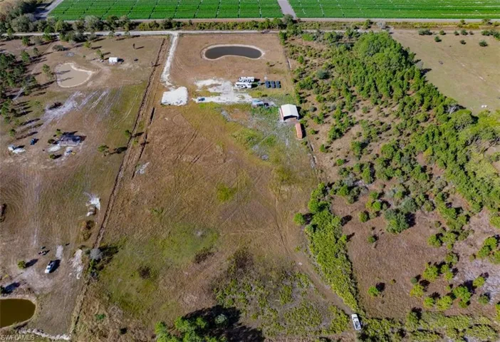 Aerial view of property and surrounding area featuring rural landscape and extensive farmland
