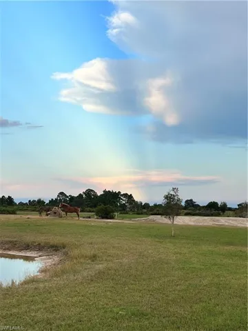 View of green lawn featuring a view of countryside and a water view