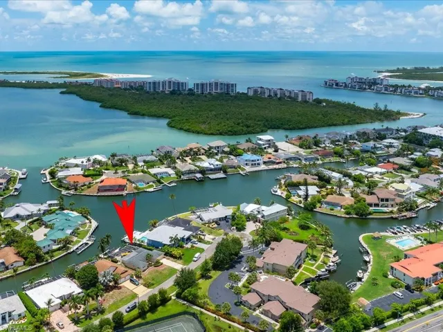 Aerial view of property and surrounding area featuring a nearby body of water and nearby suburban area