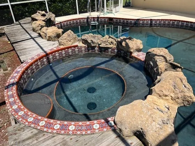 Swimming pool featuring an in-ground hot tub and a garden pond