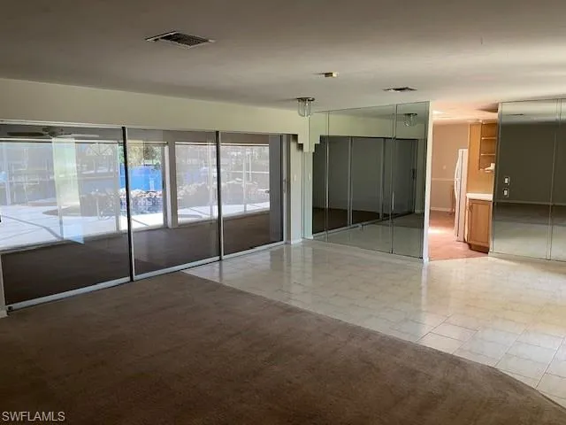 Empty room featuring light carpet and light tile patterned floors