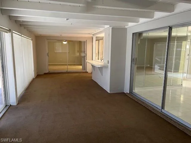 Hall featuring carpet floors and beamed ceiling