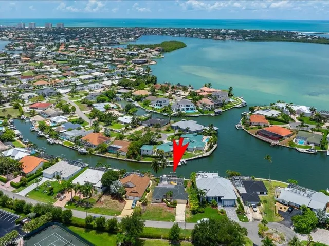 Aerial view of property's location with a nearby body of water and nearby suburban area