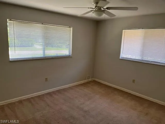 Spare room with light colored carpet and a ceiling fan