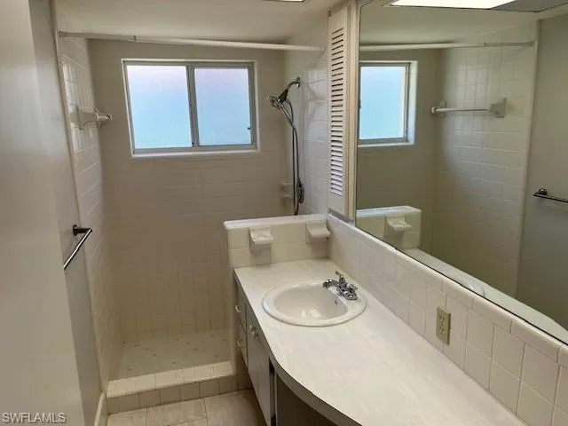 Bathroom featuring vanity, a shower stall, and light tile patterned floors