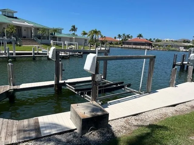 Dock area featuring boat lift, a water view, and a residential view