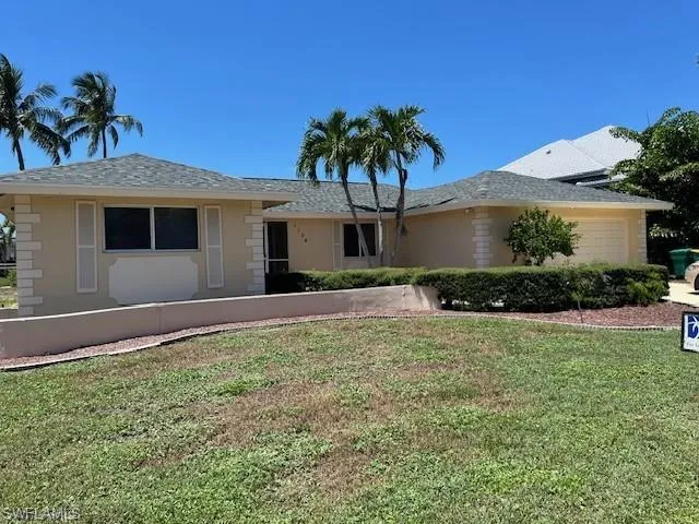 Ranch-style house with an attached garage, a front lawn, and stucco siding