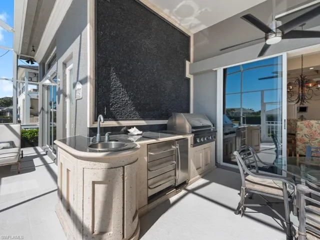 View of patio featuring area for grilling, an outdoor kitchen, a ceiling fan, and a sink