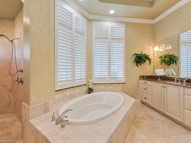 Full bath with vanity, recessed lighting, a tile shower, ornamental molding, and a bath