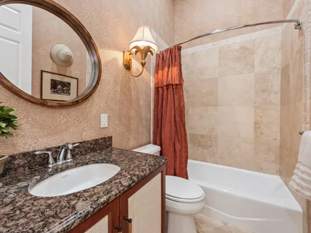 Bathroom featuring vanity, wallpapered walls, tile patterned flooring, toilet, and shower / tub combo with curtain