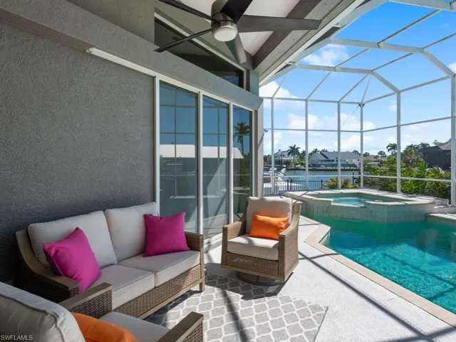 View of swimming pool featuring a ceiling fan, an outdoor living space, glass enclosure, and a patio area