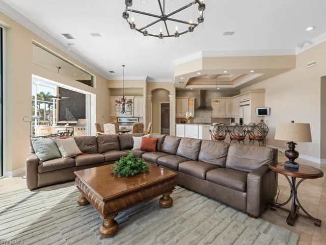 Living room featuring recessed lighting, arched walkways, and crown molding