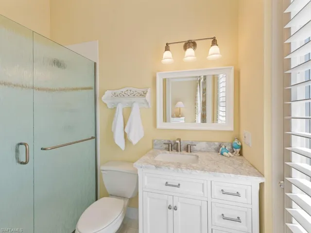 Full bathroom featuring a stall shower, toilet, and vanity