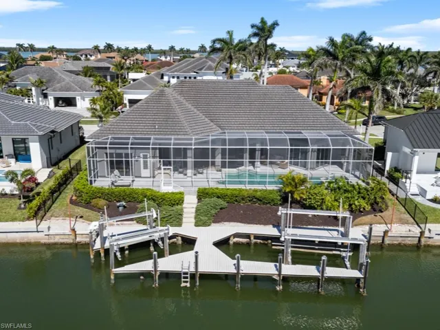 Rear view of house with an outdoor pool, a residential view, boat lift, and a water view