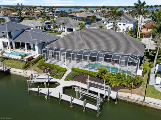 Back of house with a tiled roof, a residential view, a water view, and boat lift