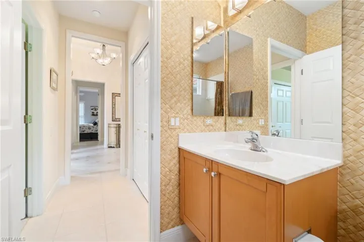 Bathroom featuring walk in shower, tile patterned flooring, vanity, and baseboards