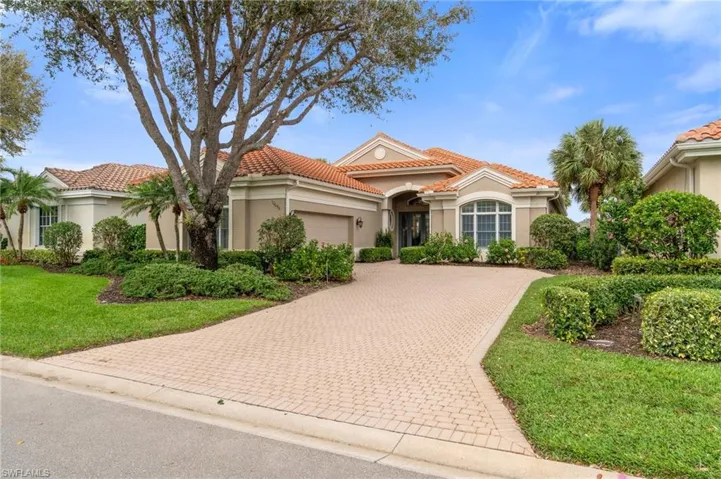 Mediterranean / spanish-style house with decorative driveway, stucco siding, a garage, a tiled roof, and a front lawn