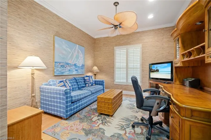 Office with ceiling fan, crown molding, and wood finished floors