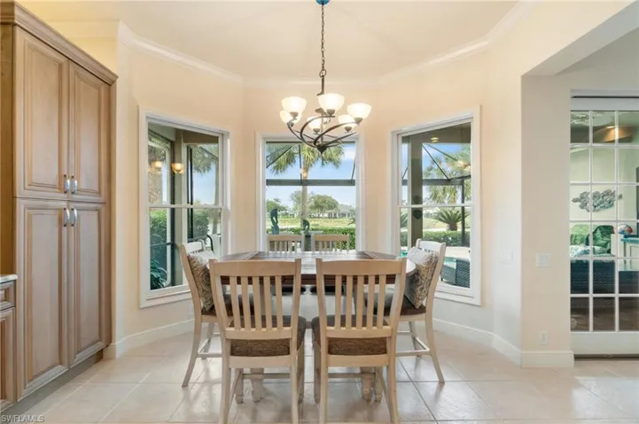Dining space featuring an inviting chandelier, baseboards, crown molding, and light tile patterned flooring