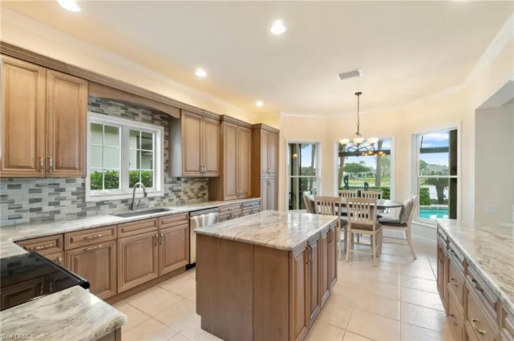 Kitchen with visible vents, a sink, dishwasher, and light stone countertops
