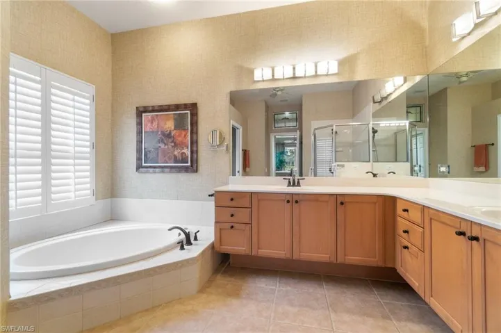 Full bath with a garden tub, a sink, a shower stall, and wallpapered walls