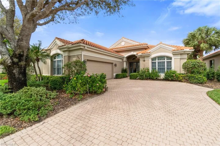 Mediterranean / spanish home with a garage, decorative driveway, a tiled roof, and stucco siding