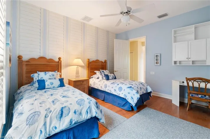 Bedroom with baseboards, visible vents, and wood finished floors