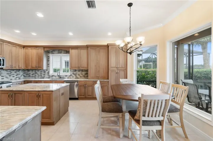 Kitchen featuring light tile patterned floors, a sink, visible vents, appliances with stainless steel finishes, and decorative backsplash