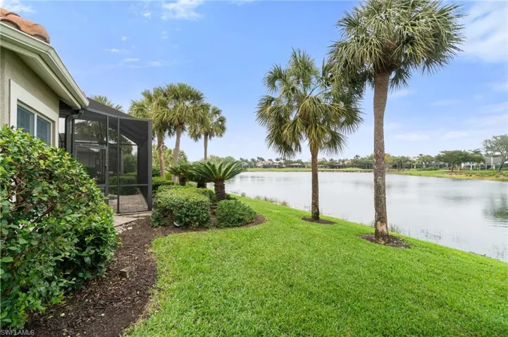 View of yard featuring glass enclosure and a water view