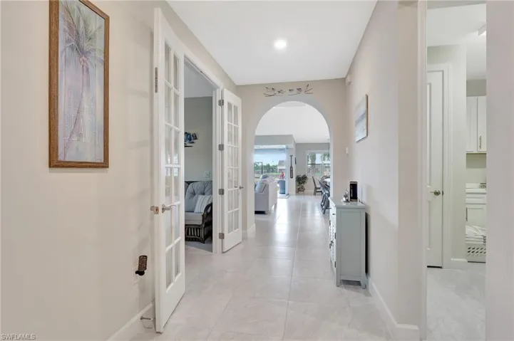 Corridor with light tile patterned flooring and french doors