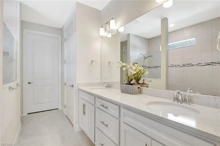 Bathroom featuring a shower, tile patterned flooring, and vanity