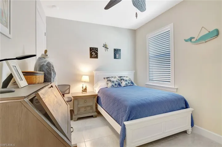 Bedroom with multiple windows, ceiling fan, and light tile patterned floors