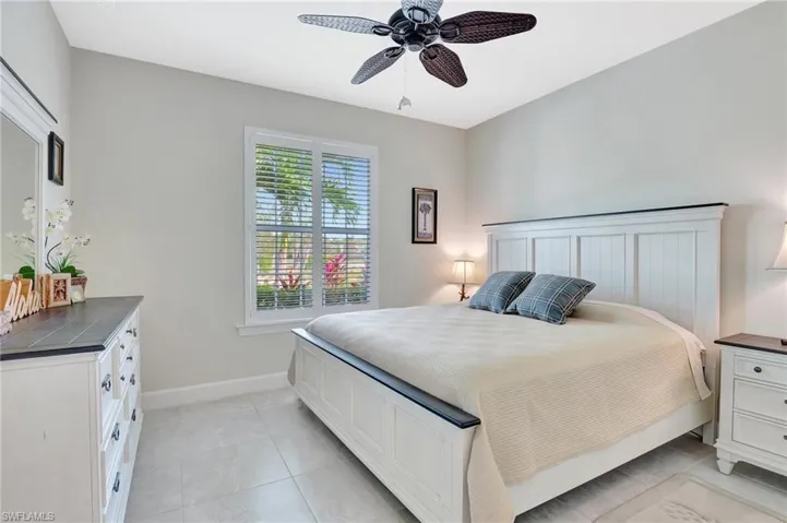 Tiled bedroom featuring ceiling fan