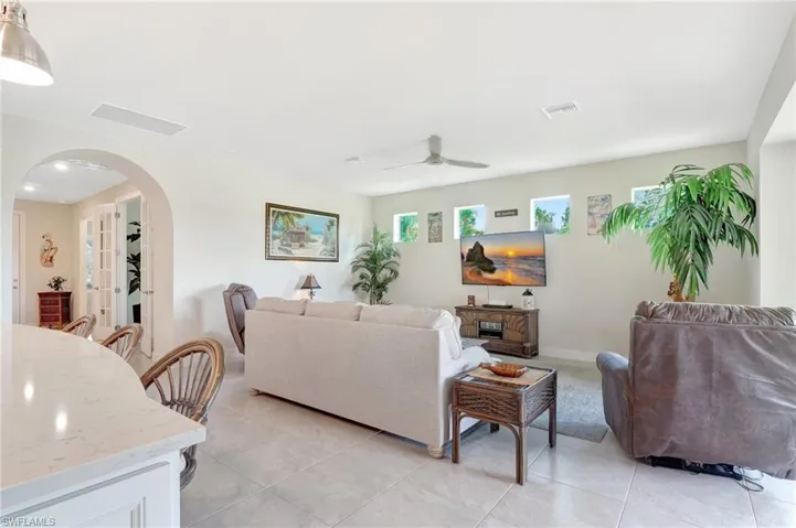 Living room with ceiling fan and light tile patterned floors