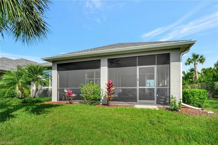 Back of house with a sunroom and a lawn