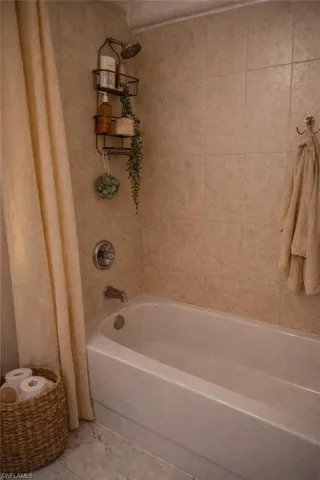 Bathroom with shower / bath combination with curtain
