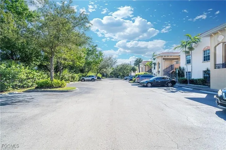 View of asphalt street featuring a residential view and curbs