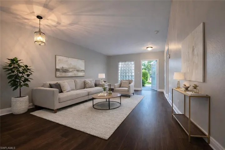Living area featuring baseboards and dark wood-style floors