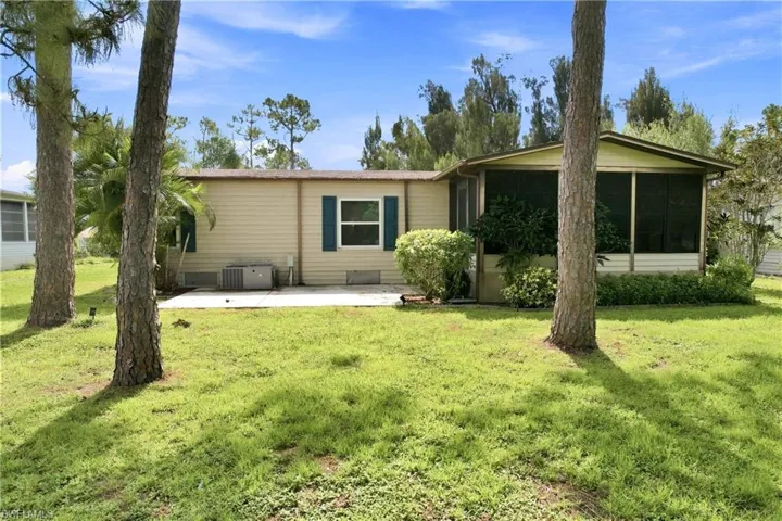 Exterior featuring beige horizontal siding, a screened-in porch, and a concrete patio