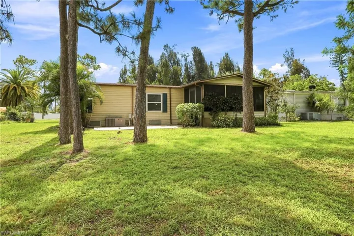 Expansive green lawn surrounds a single-story residence with a screened patio