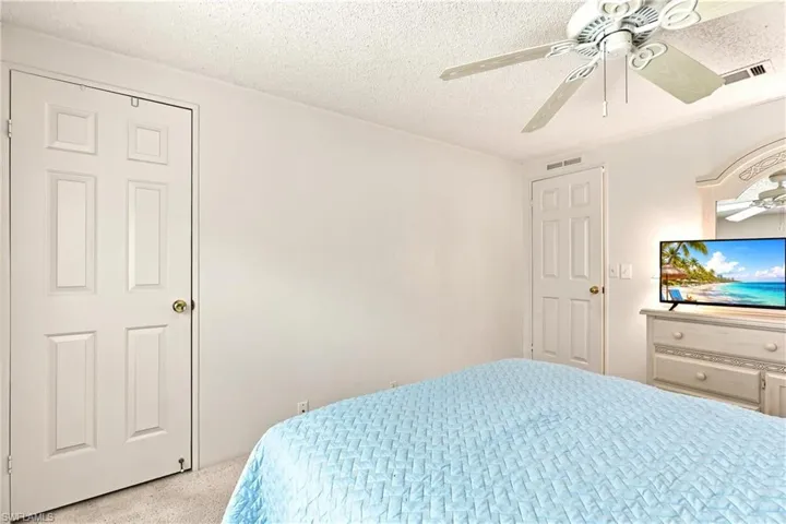 Neutral color palette featuring white walls and textured carpet flooring