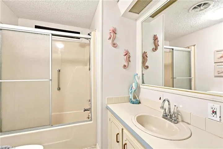 Bathroom featuring a full vanity with an integrated sink, polished chrome faucet, and a large mirror